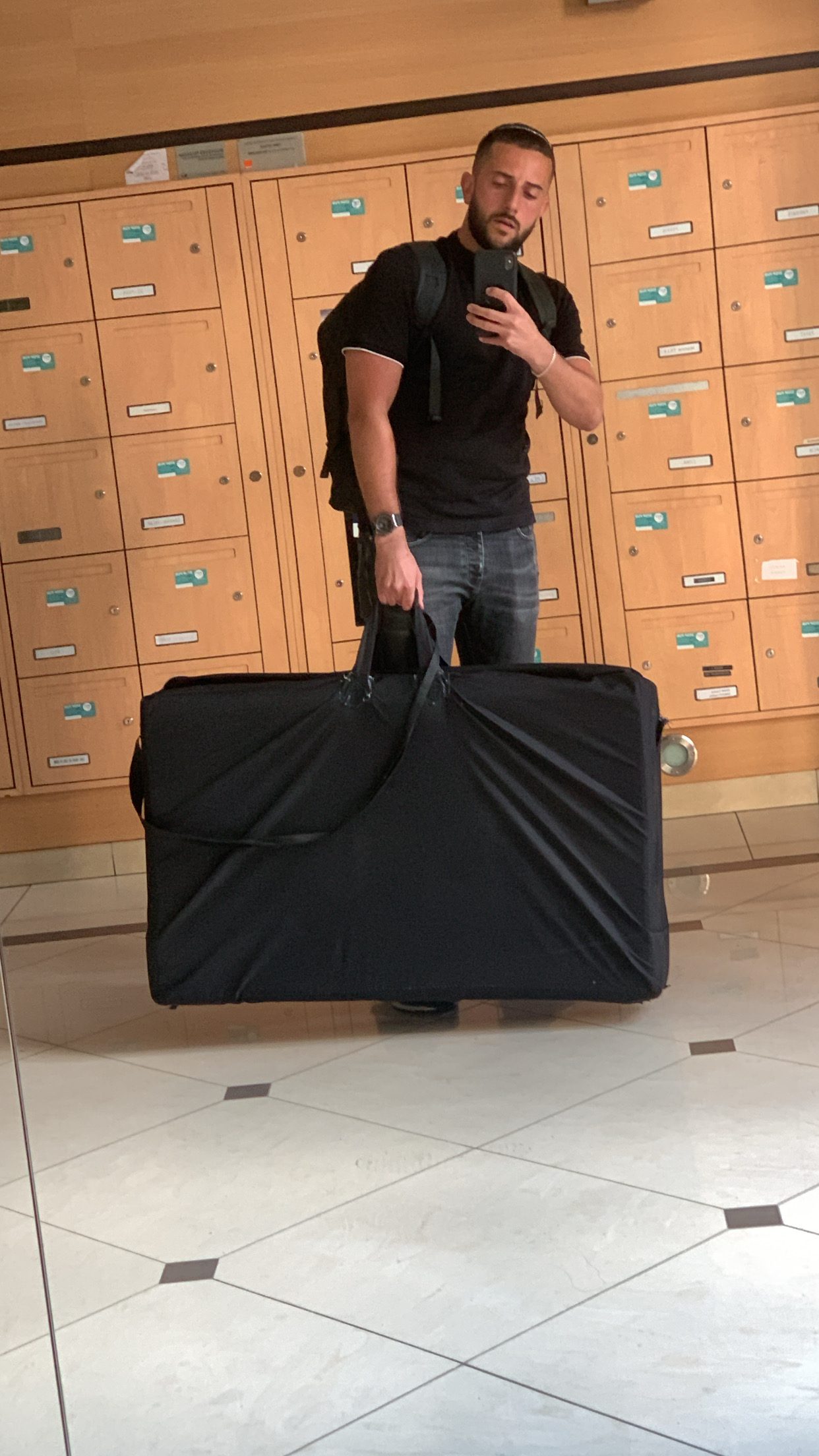 Elie Slomczynski, ostéopathe, transportant sa table de soins pliante pour une consultation à domicile